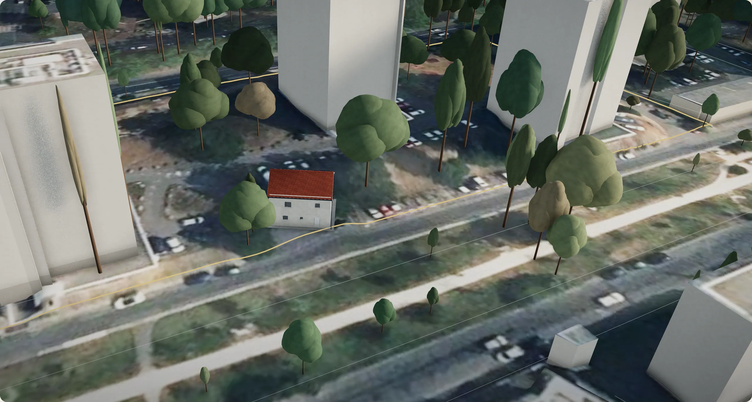 La maison du projet dans son quartier, vue du ciel à 17 h 30 : une toiture rouge entre des arbres et des immeubles, le long d’une rue.